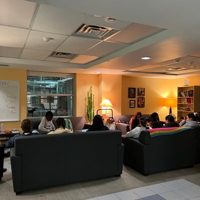 a group of students sitting in the link inclusion lounge reading
