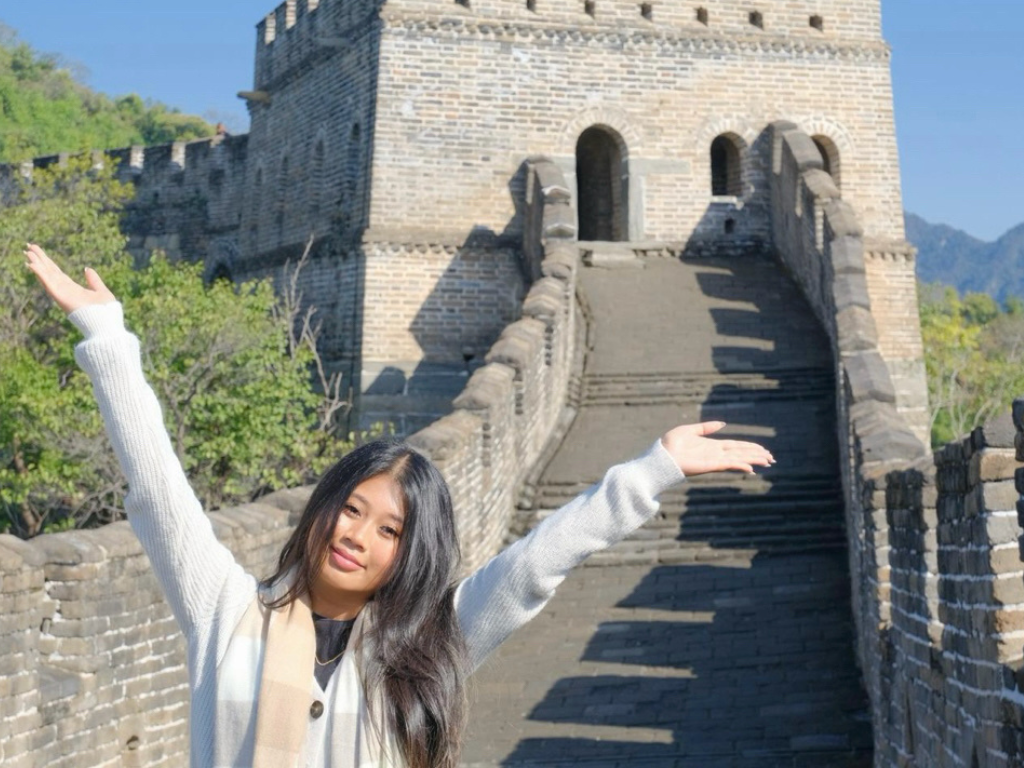 student posing on the great wall of china 