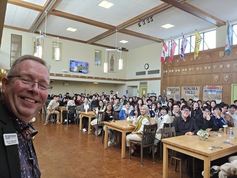 Marc Jerry taking a selfie in front of a group of International students in the Great Hall