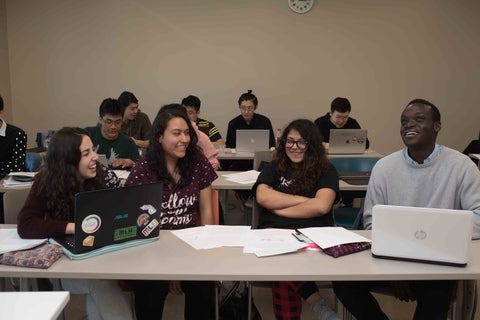 Students sitting at a table in a classroom. 