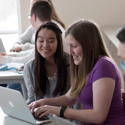 Two students working at a laptop. 