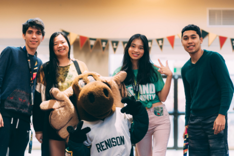 Four students standing with Reni Moose
