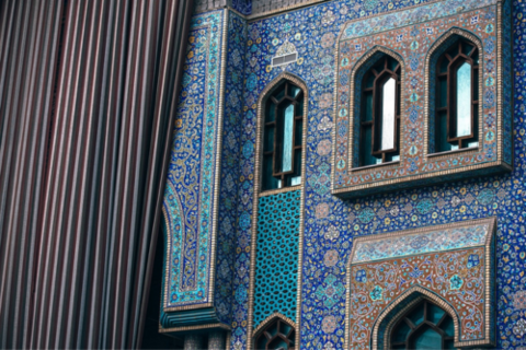 Exterior of a building with arched windows and mosaics. 