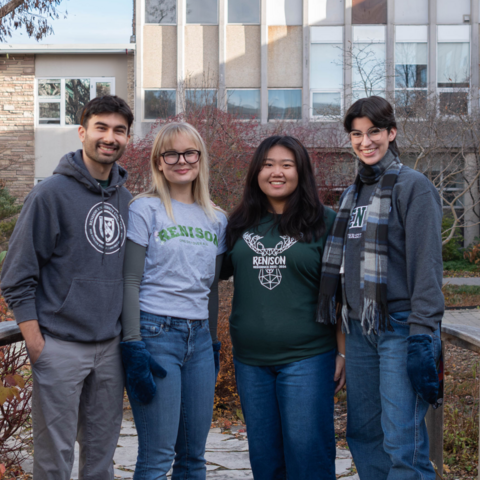 Four students standing on the bridge in Renison's courtyard. 