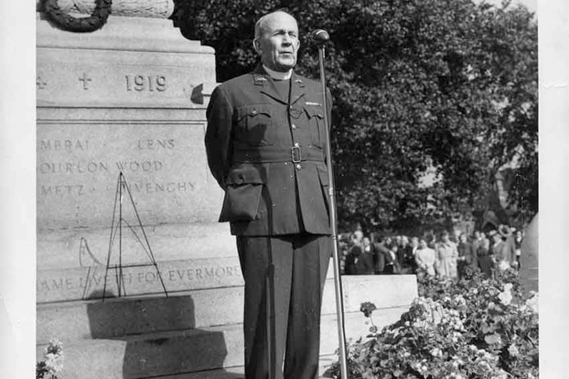 Photograph of Rev. Robert J. Renison in front of the North Bay cenotaph 