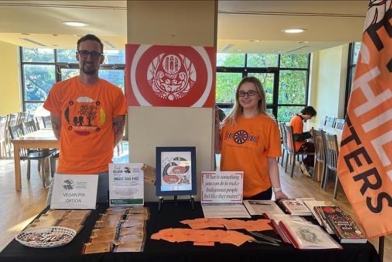 Two people standing at a booth for National Day for Truth & Reconciliation