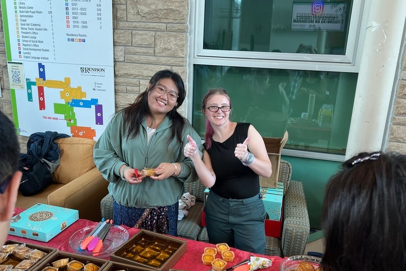 two people behind a booth with Chinese treats