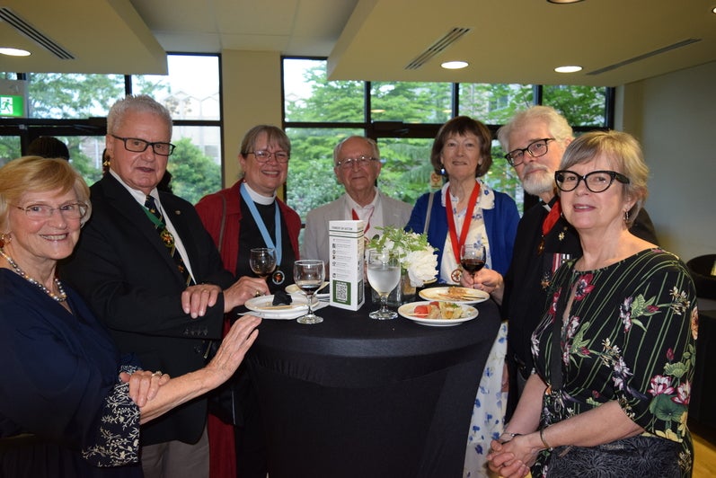 7 people around a table at the reception for Founders Day 2024. 