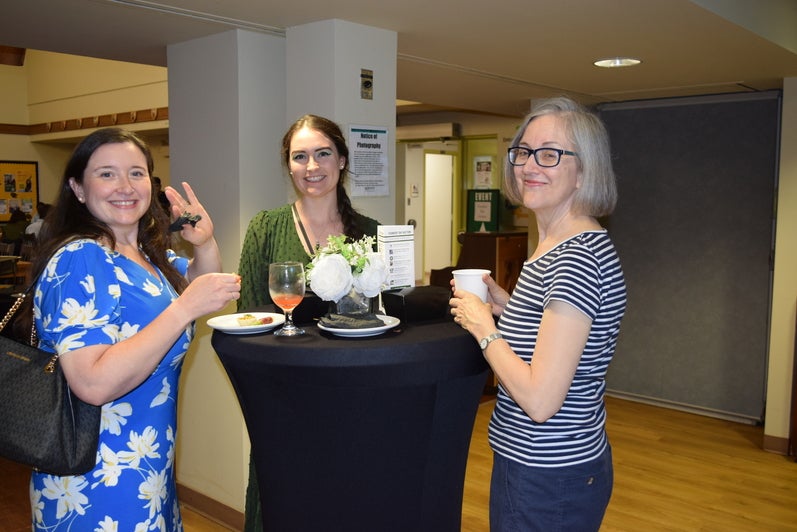 Three people standing around a table at the Founders' Day 2024 reception. 