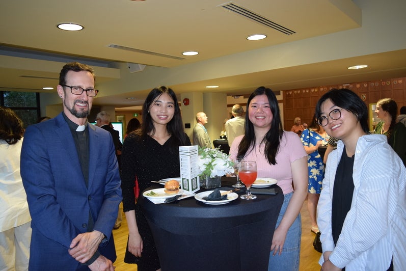 Four people standing around a table at the Founders' Day 2024 reception. 