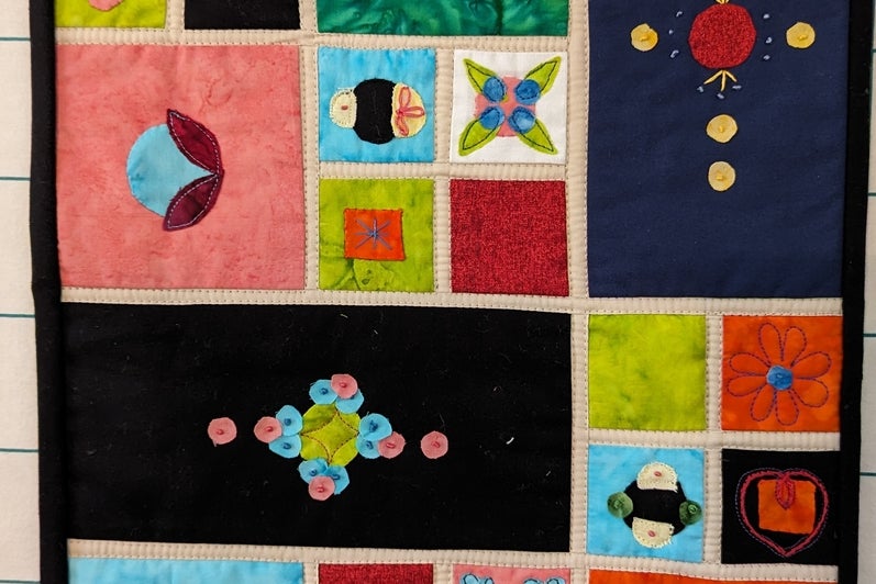A colourful quilt with varying patterns showing different designs. 