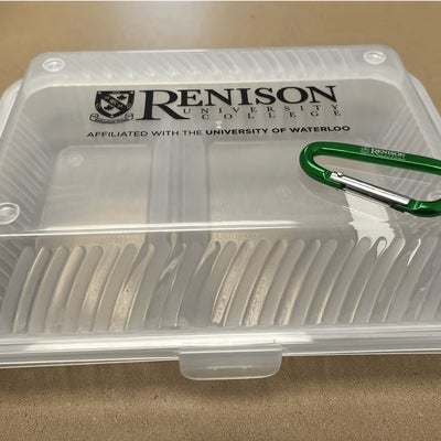 A plastic container with the Renison logo on it, and set on top of it is a green carabiner. 