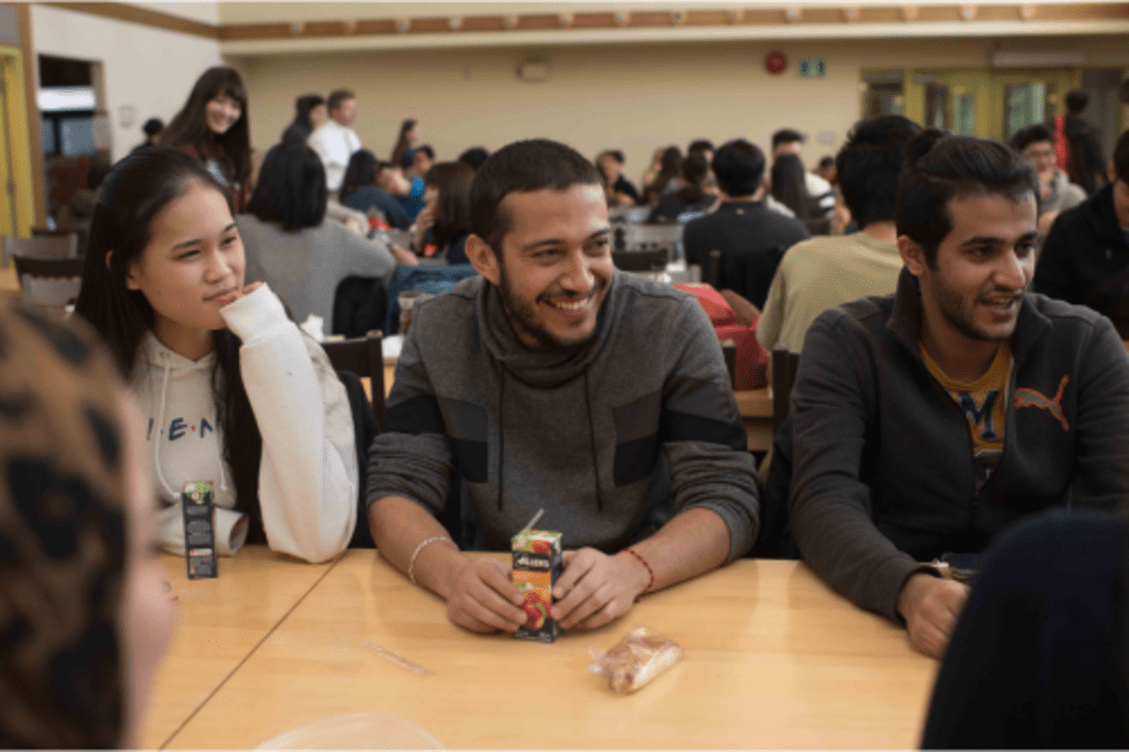 Three students sitting in the Renison cafeteria. 