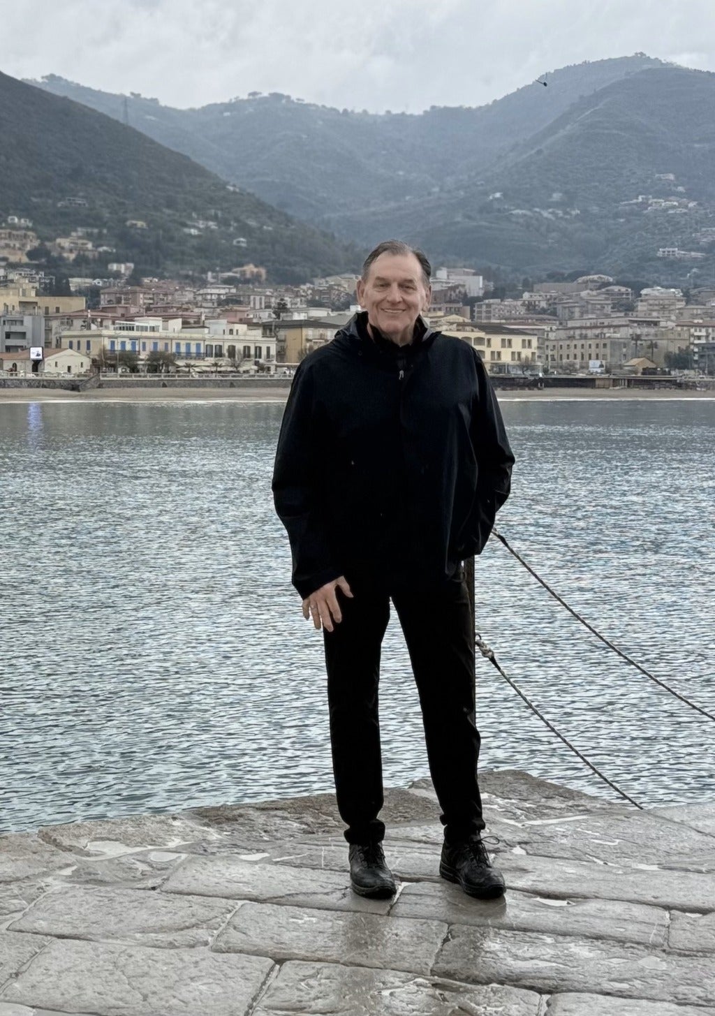 Doug Austrom standing in front of a mountain and townscape. 