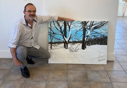 Henry Doucette next to one of his paintings.