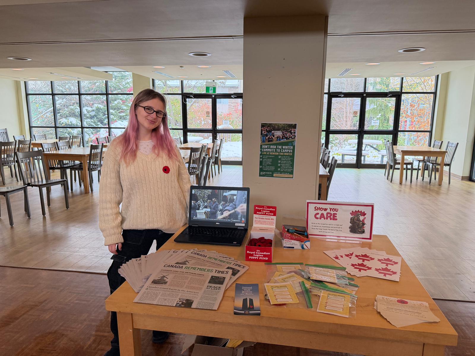 Student next to a booth inside a cafeteria area