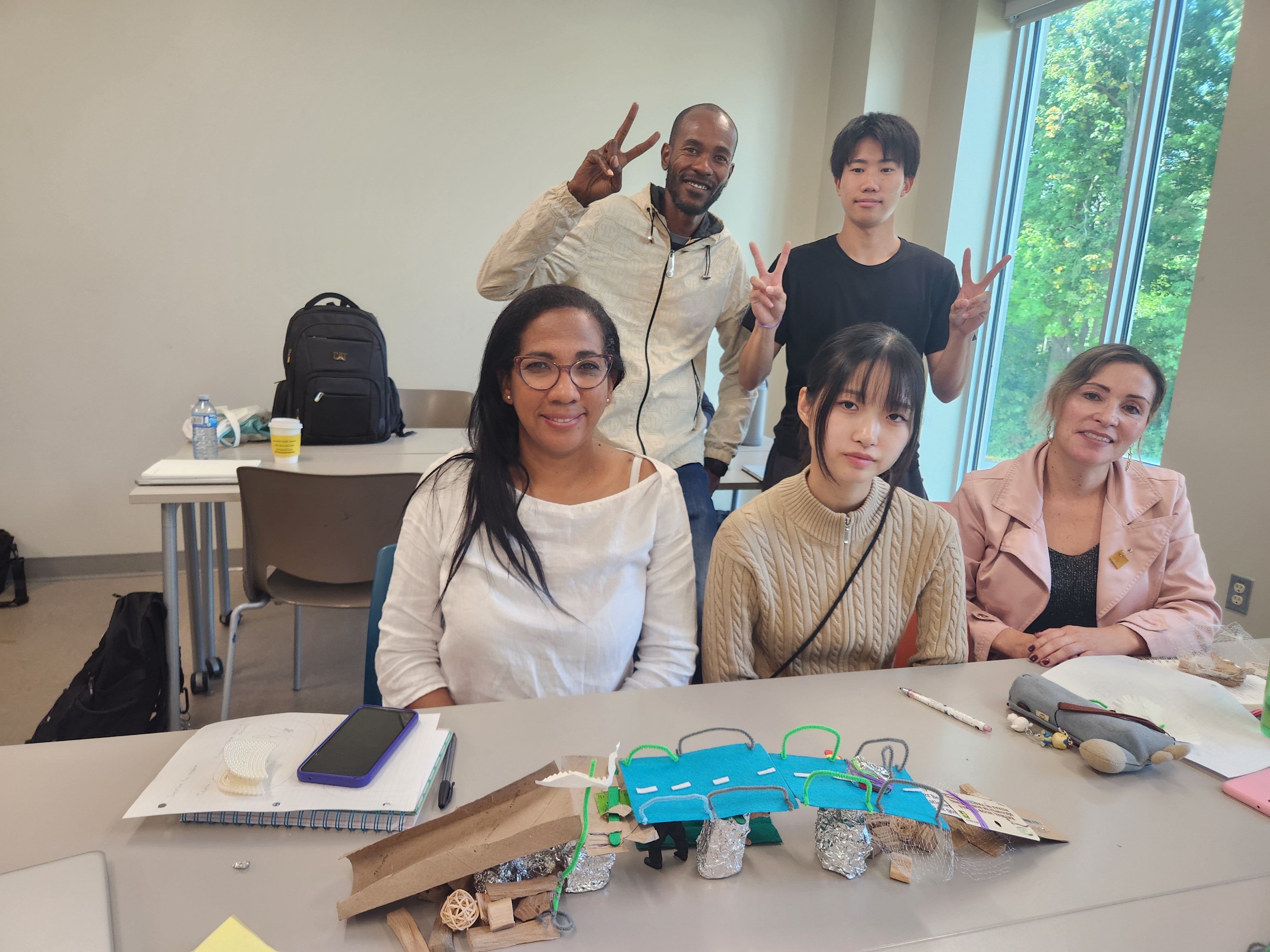 Five students in a classroom working on a design. 