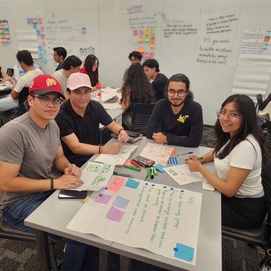 Students sitting around a table working on a project. 