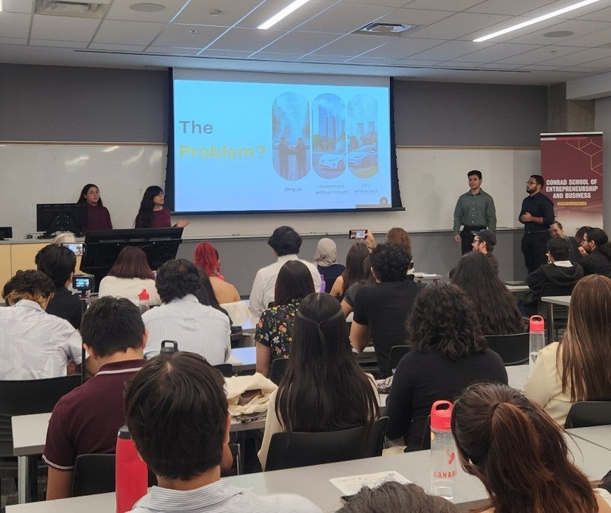 Students at the front of a classroom during a presentation. 