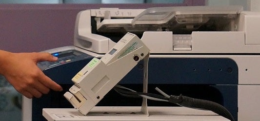 A hand using a photocopier