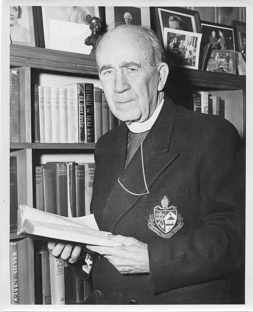 Black and white photo of Bishop Renison in front of a bookcase