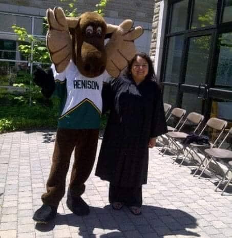 Robin stands with Renison mascot Reni Moose at her graduation in 2012. 