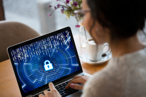 Person typing on a laptop keyboard with an image of a padlock