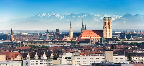 European city with snow capped mountains in the background.
