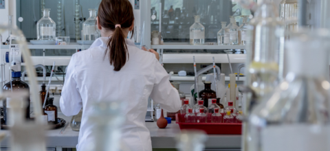 Person in a lab coat in front of lab bench