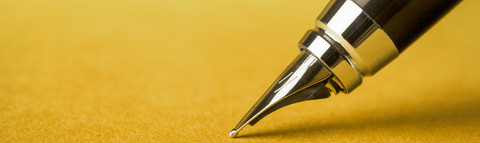 Tip of a fountain pen on a gold background