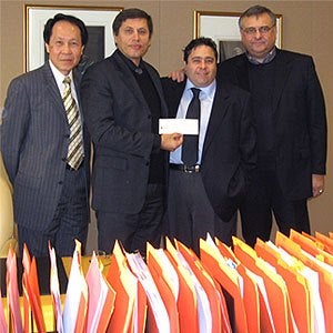Sam Visaisouk, left, and Tom Corr, right,  of WatCo pose with researcher Tizhoosh and First  Leaside representative Leon Efraim at a cheque  presentation in early December.