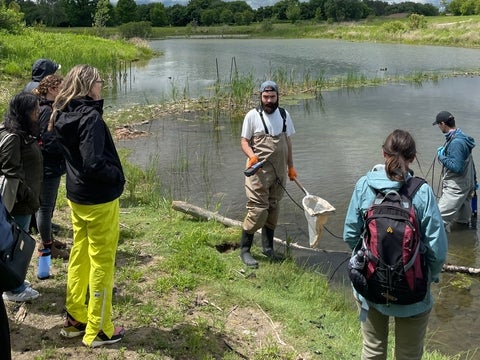 RISE team member Liahm Ruest provides a demonstration of biodiversity sampling from a stormwater pond. 