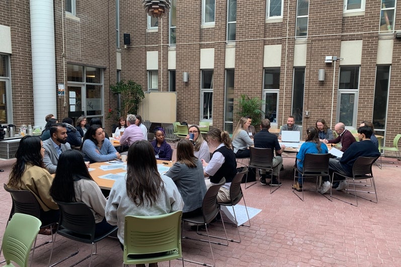 Participants sitting at round tables for the World Cafe activity.