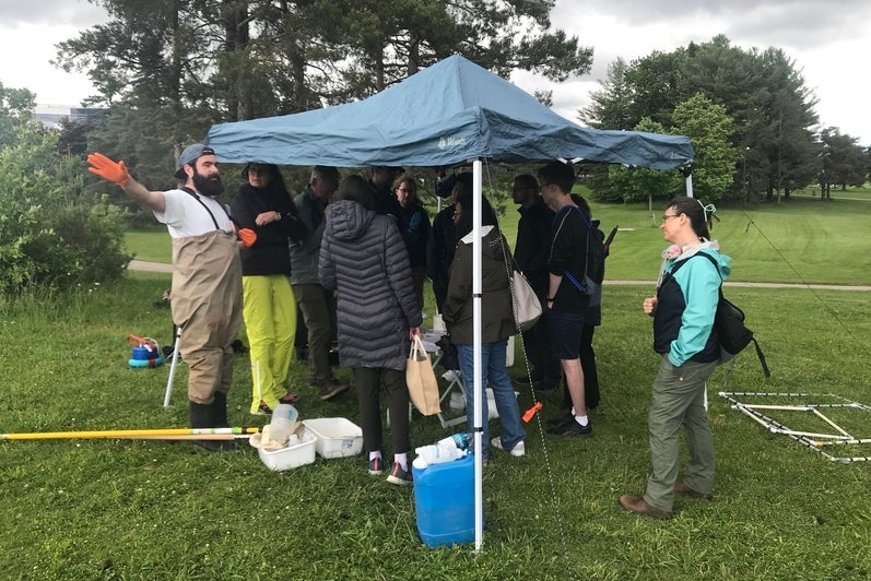 Participants gathered underneath a tent while to learn about biodiversity sampling from team member Liahm Ruest. 