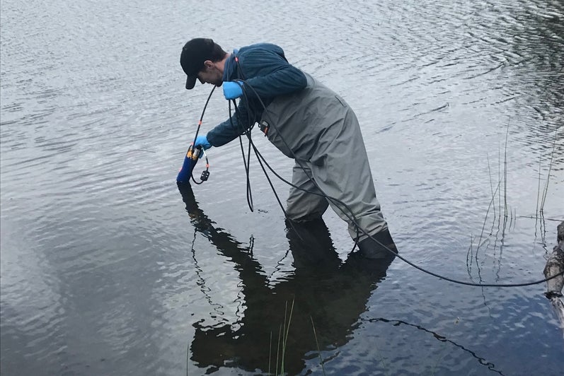 Close-up of RISE team member taking water quality samples in Columbia Lake. 