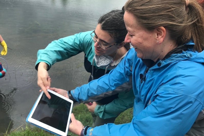 Dr. Maria Strack and Dr. Rebecca Rooney looking at the live methane flux measurements on an iPad.