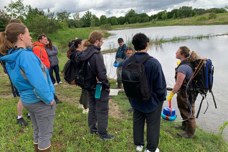 Field day participants at Columbia Lake listening to RISE team member Rayden Laliberte explain how she uses the floating methane gas chamber. 