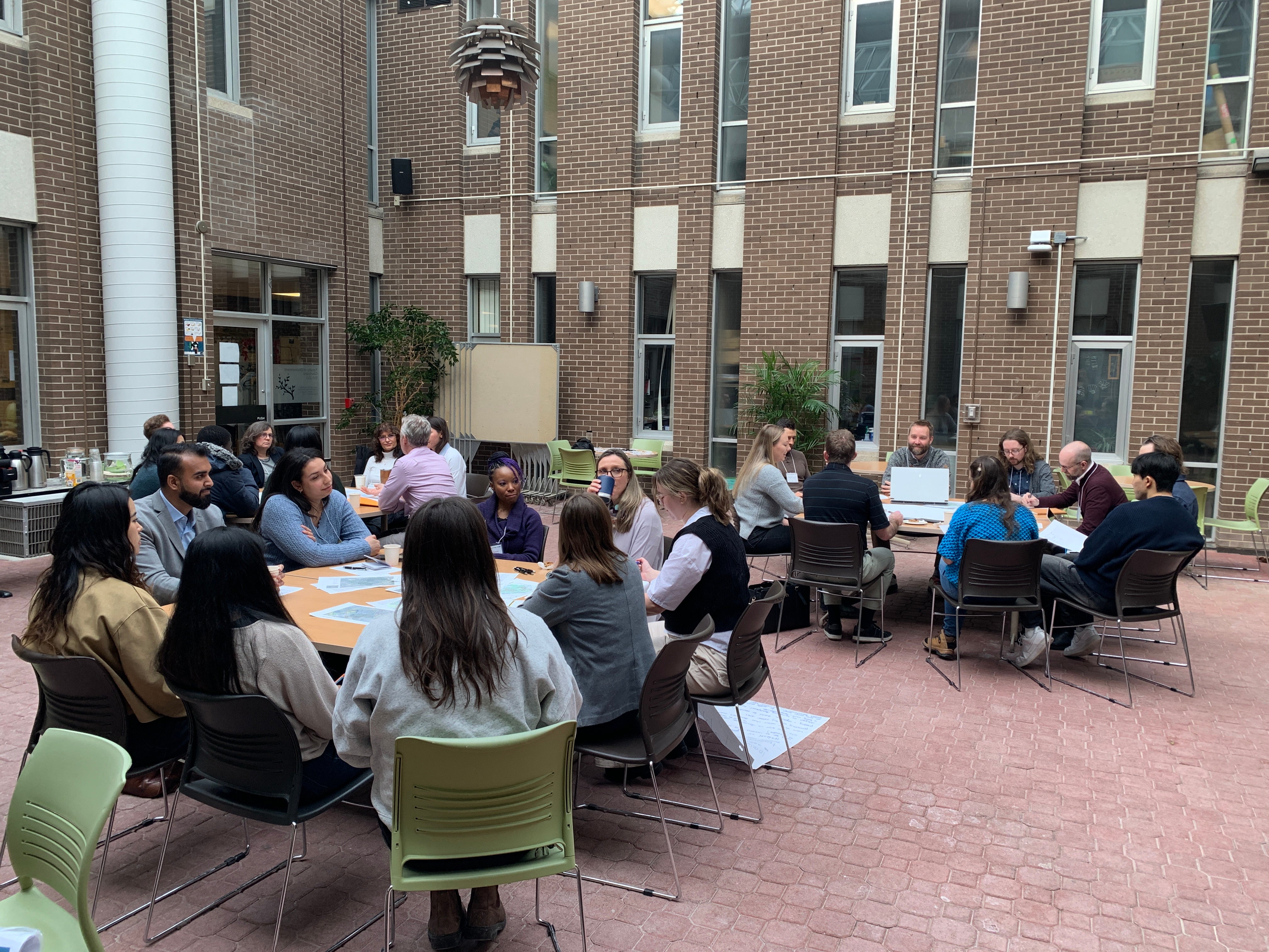 Participants sitting at round tables for the World Cafe activity.