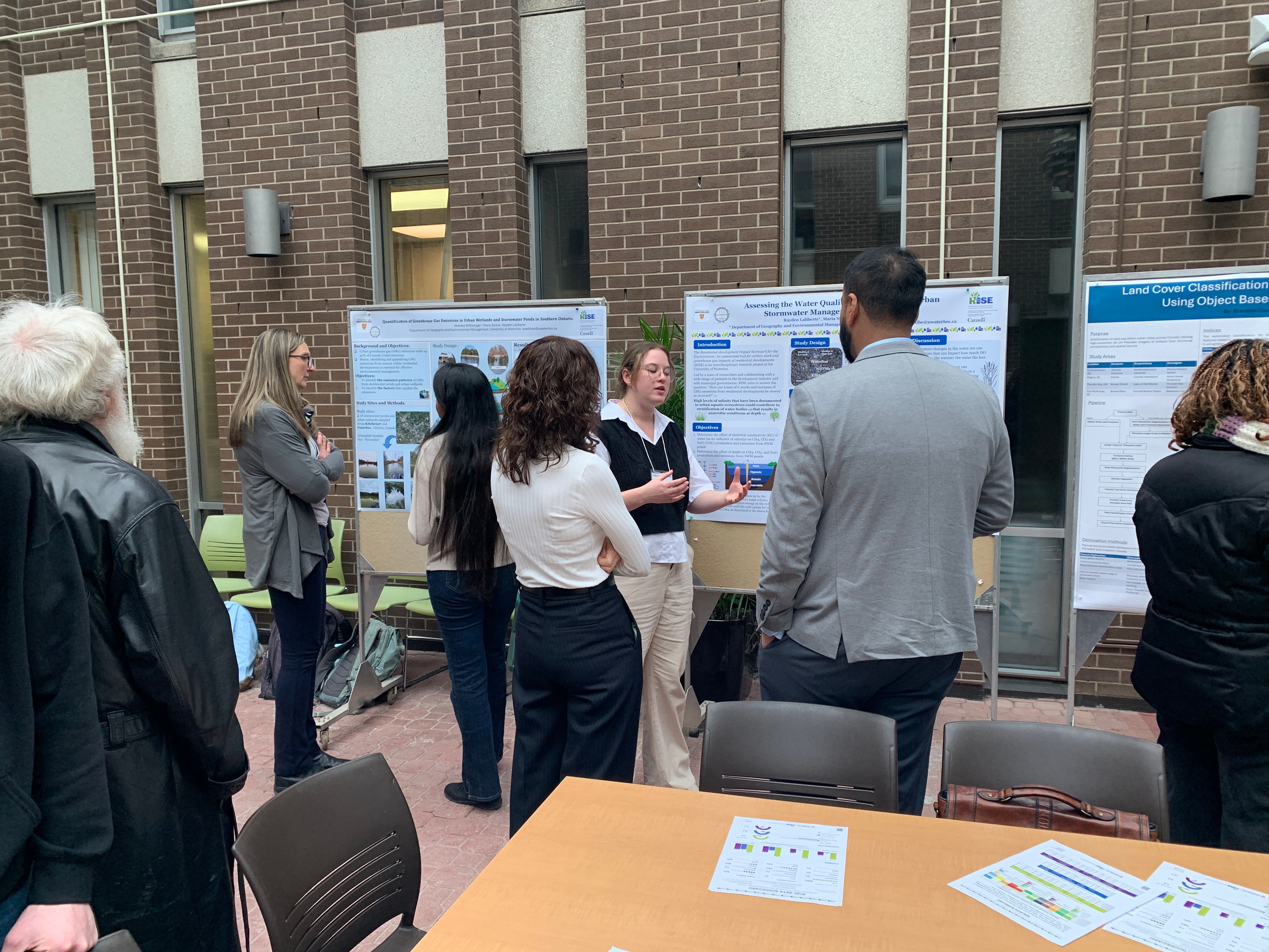 Student Rayden Laliberte talking to partners about her poster.