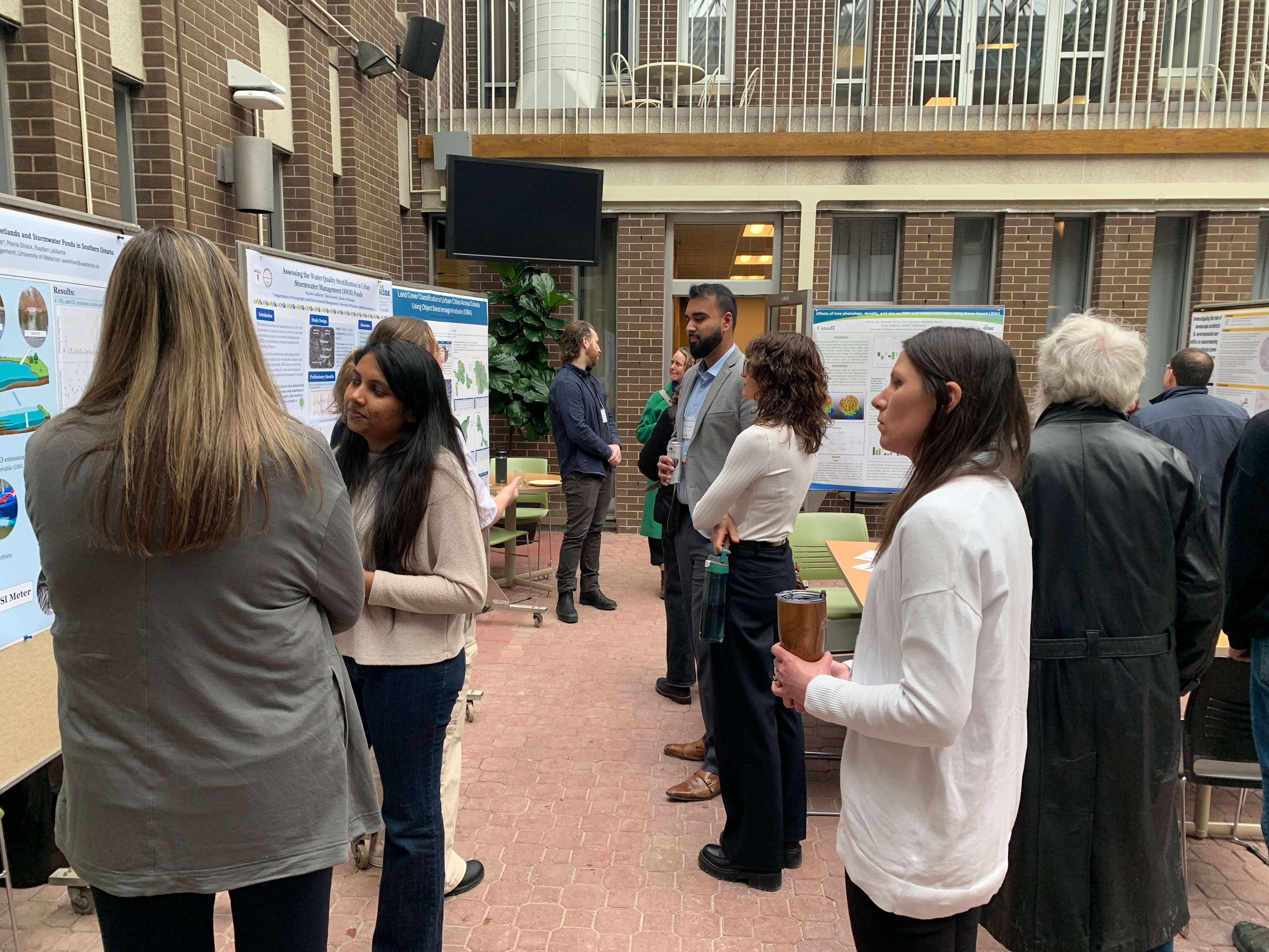 Project partners listening to students talk about their posters.