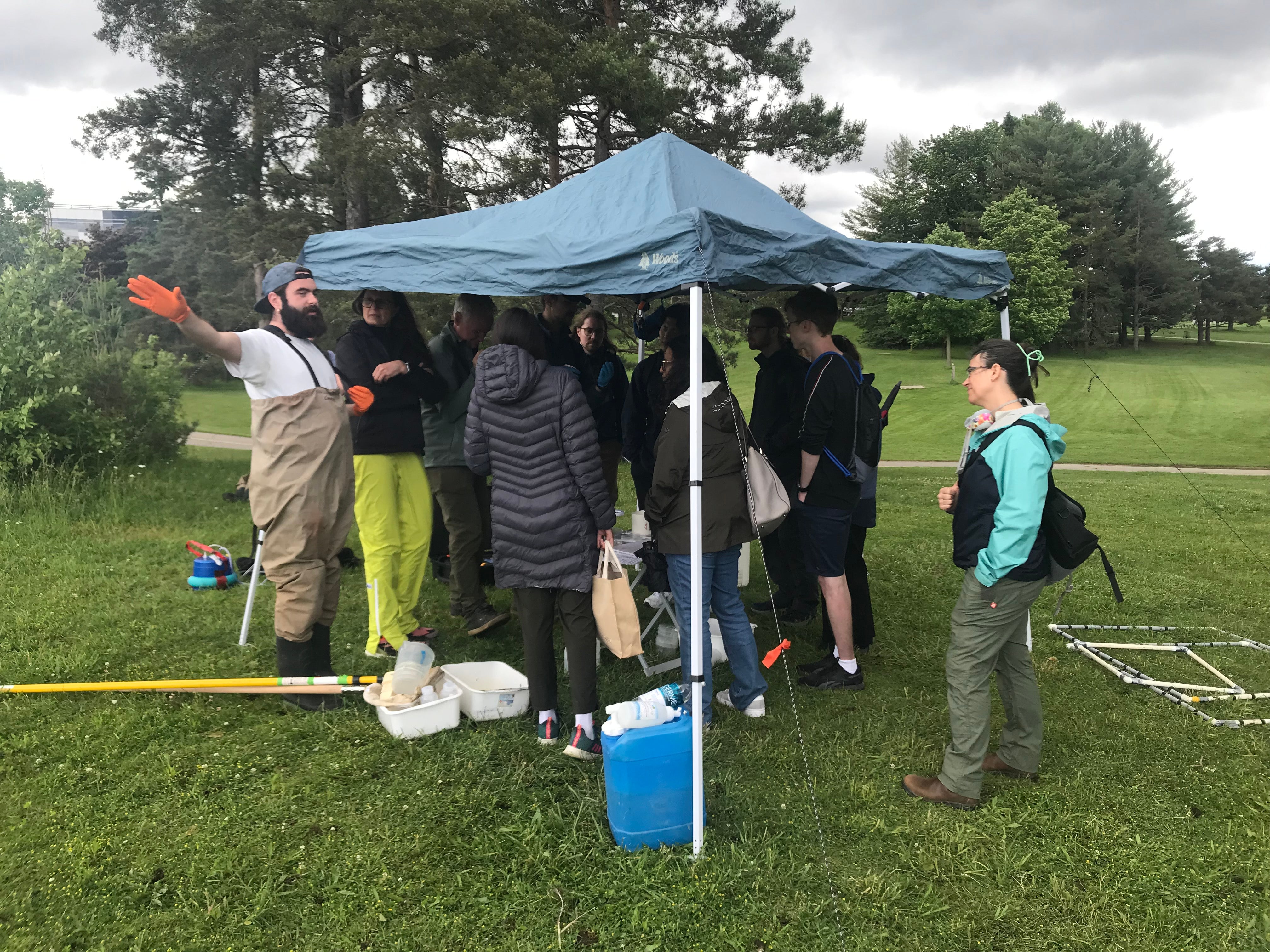 Participants gathered underneath a tent while to learn about biodiversity sampling from team member Liahm Ruest. 