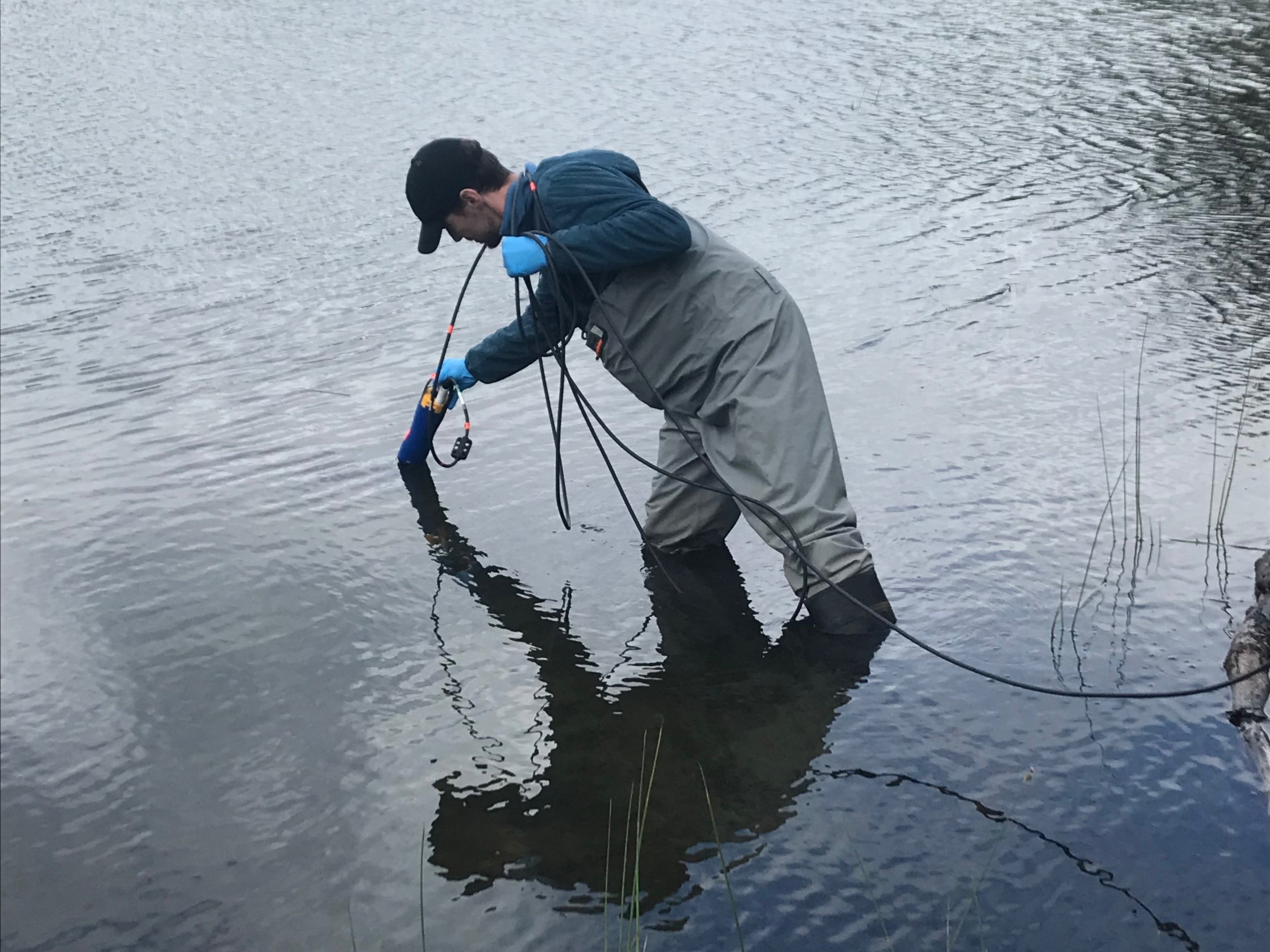 Close-up of RISE team member taking water quality samples in Columbia Lake. 