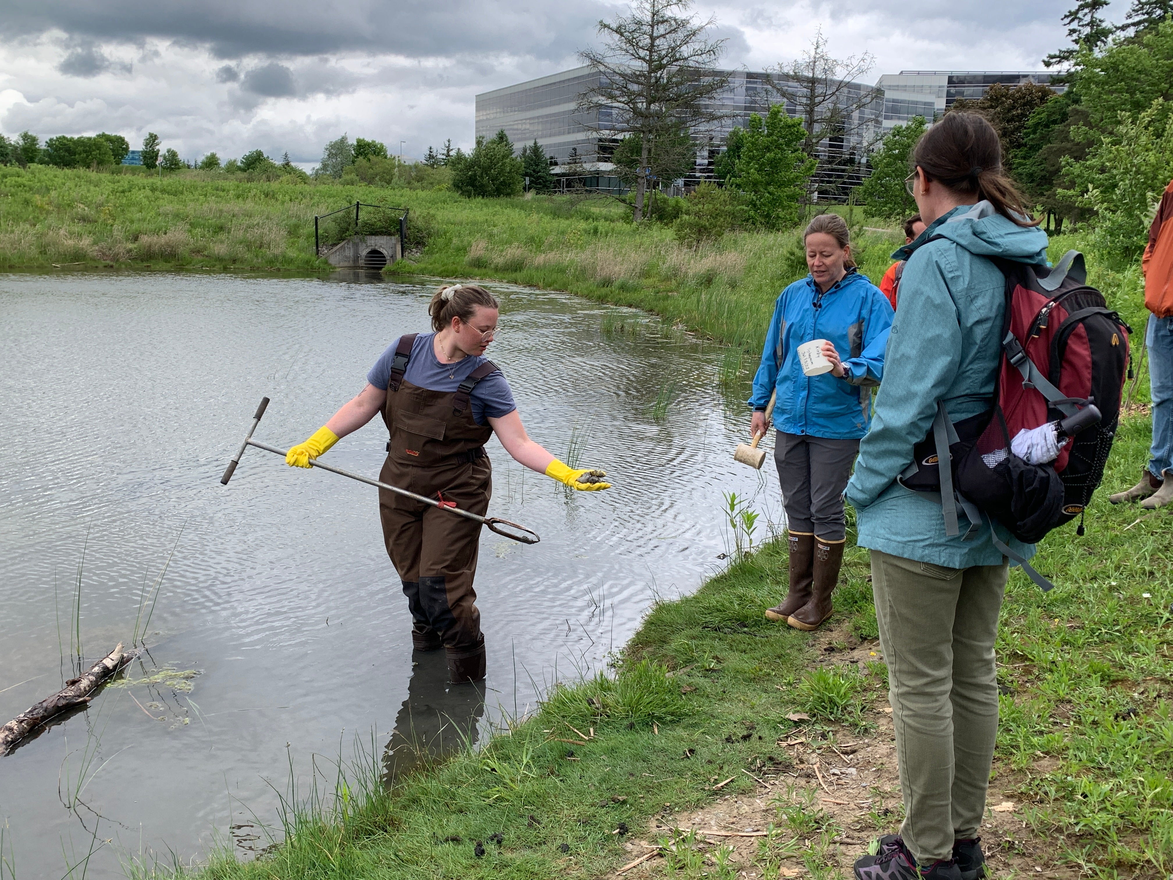 RISE team member Rayden Laliberte showing a pond sediment sample to Dr. Maria Strack and other field day participants. 