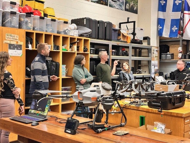 Participants surrounding drones in the Uncrewed and Remote Sensing Innovation Centre.