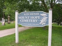 Grey sign with white lettering of Kitchener Mount Hope Cemetery.