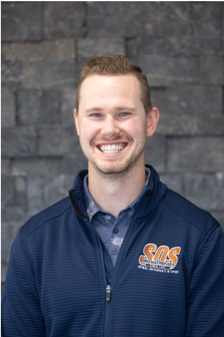 Ryan Wark wearing a dark grey collared shirt and casual jacket.