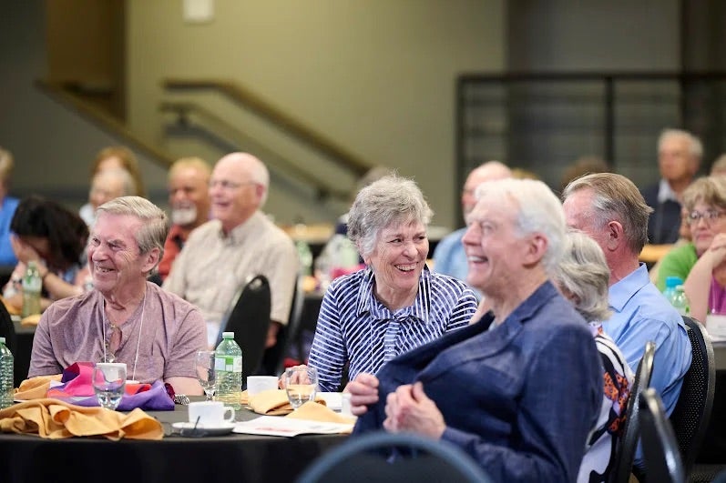 Guests laughing at Dr. Shonk's presentation about humour.