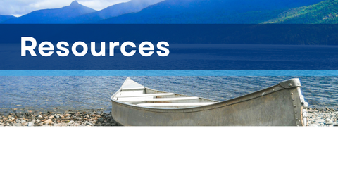 A white canoe on a lake shore with text that reads, "Resources"