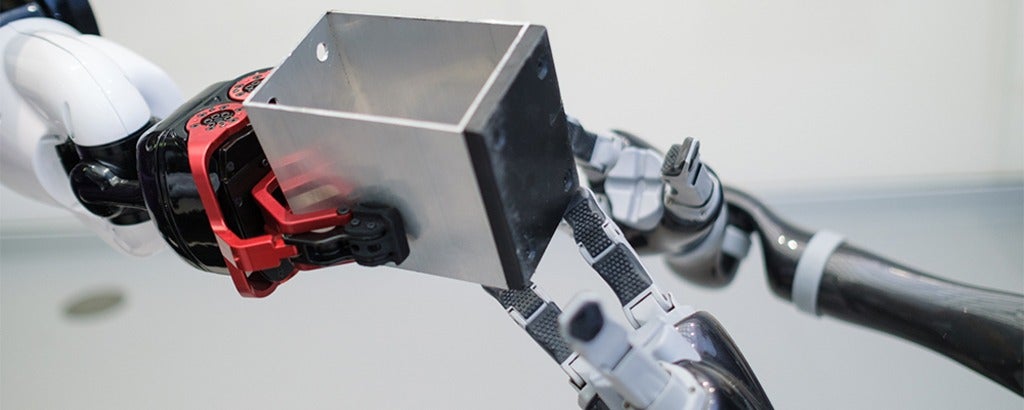 TALOS robot handing metal block to MOVO robots