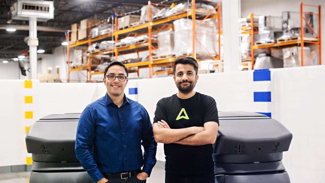 The founders of Avidbots, Pablo Molina and Faizan Sheikh, in front of their flagship product, the NEO autonomous floor scrubbing robots.